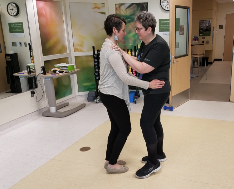 Gabriela helping a woman student with her TangoStride lesson.