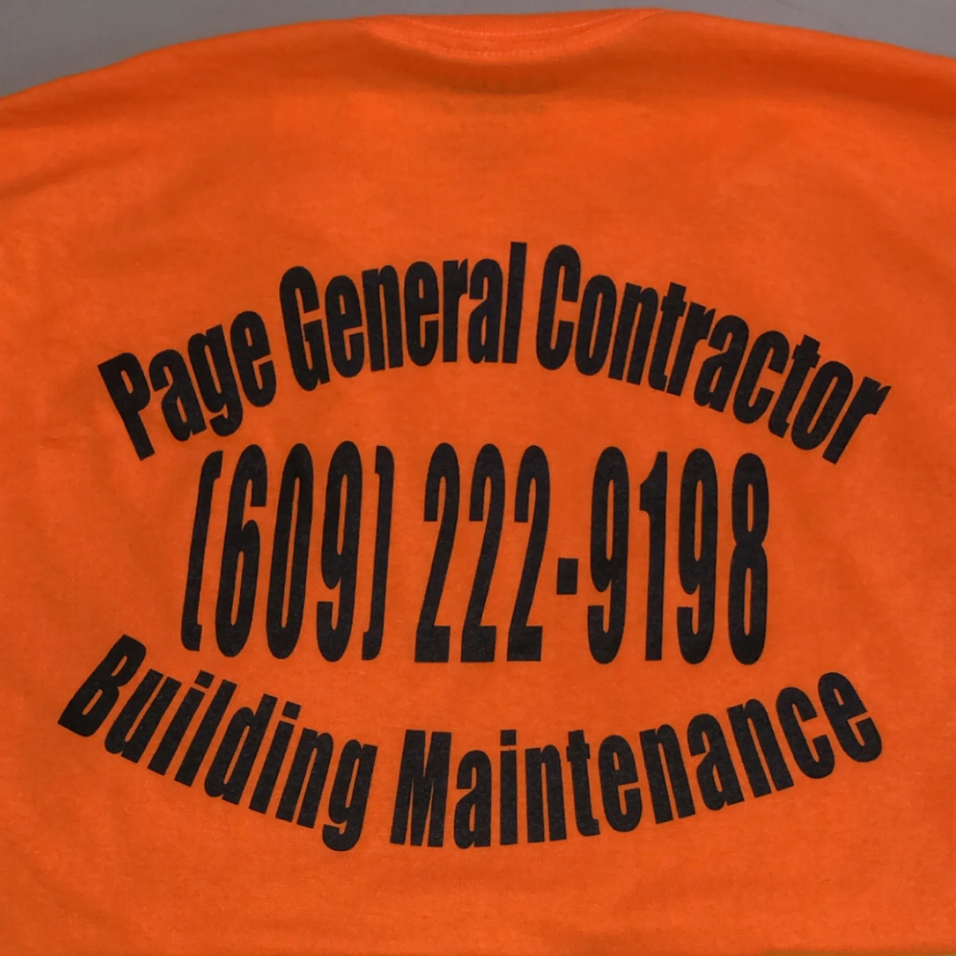 Close-up of an orange t-shirt with black text in a circular pattern, mentioning the Pew Research Center on page general census.