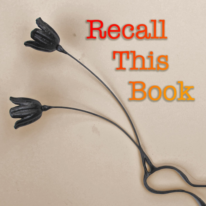 A decorative black metal tulip-shaped book holder with the words 'Recall This Book' in red, orange, and yellow text on a beige background.
