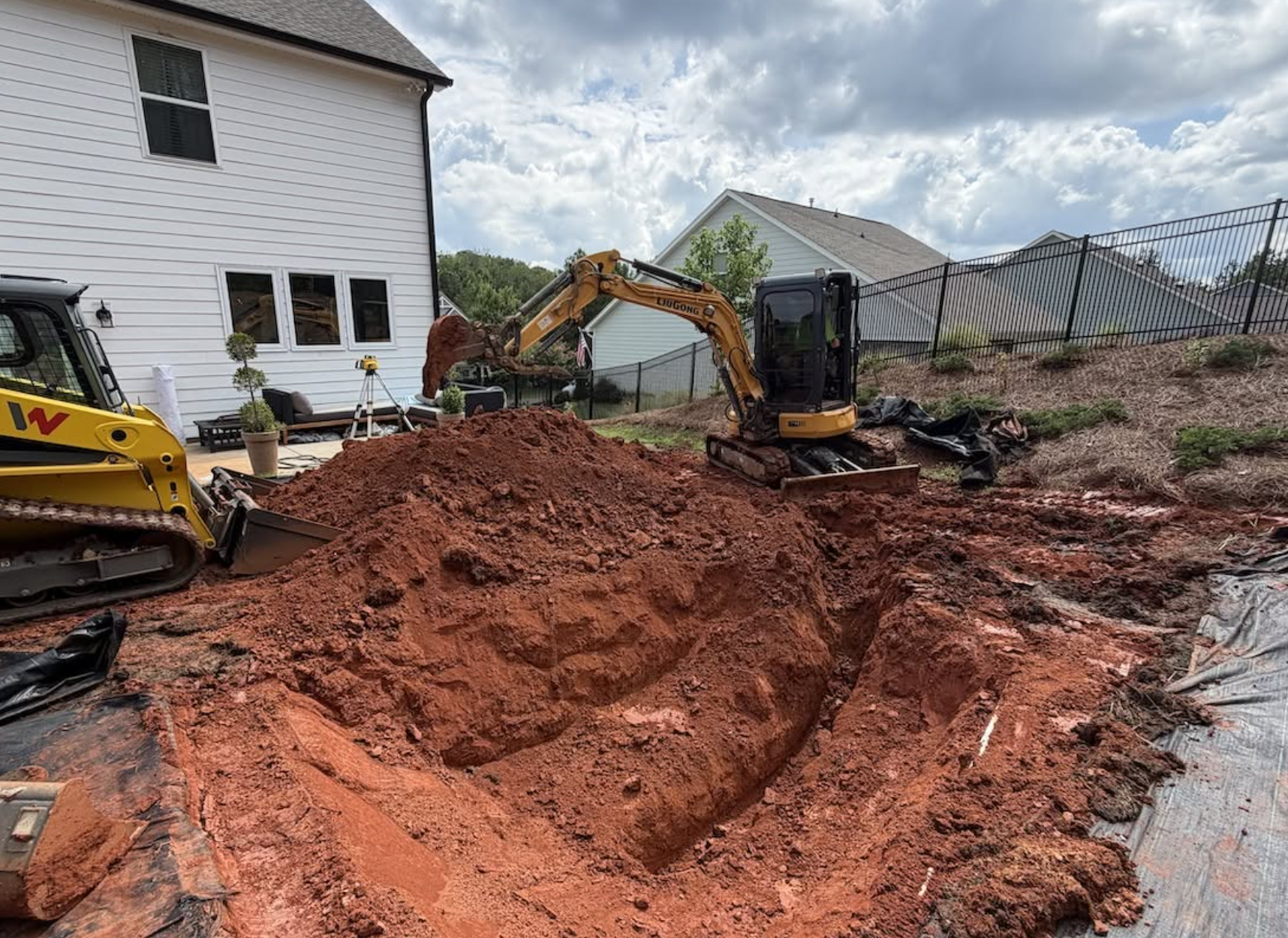 Excavated backyard area prepared for a custom in-ground trampoline installation in Lancaster, SC
