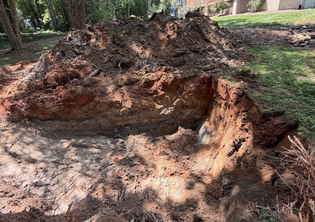Large sinkhole excavation before structural fill, grading, and drainage improvements completed by Palmetto South Construction in the Charlotte region.