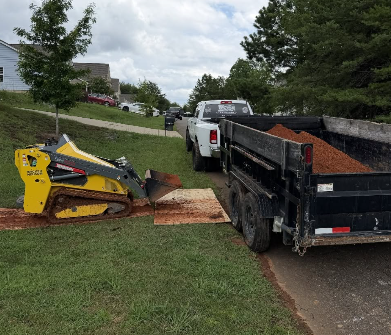Palmetto South Construction performing site work with a skid steer and dump trailer in York County, South Carolina.