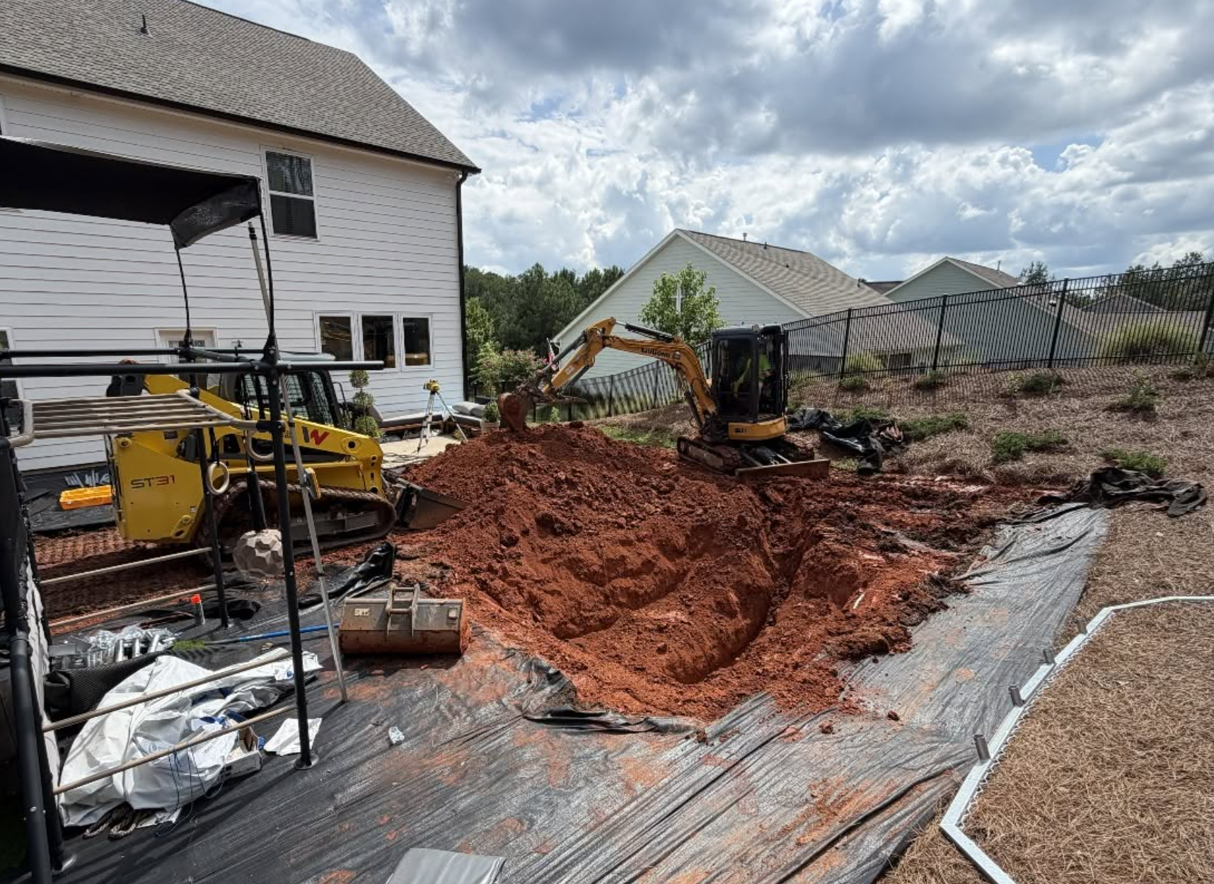 Backyard excavation and grading underway for an in-ground trampoline installation in Lancaster, SC