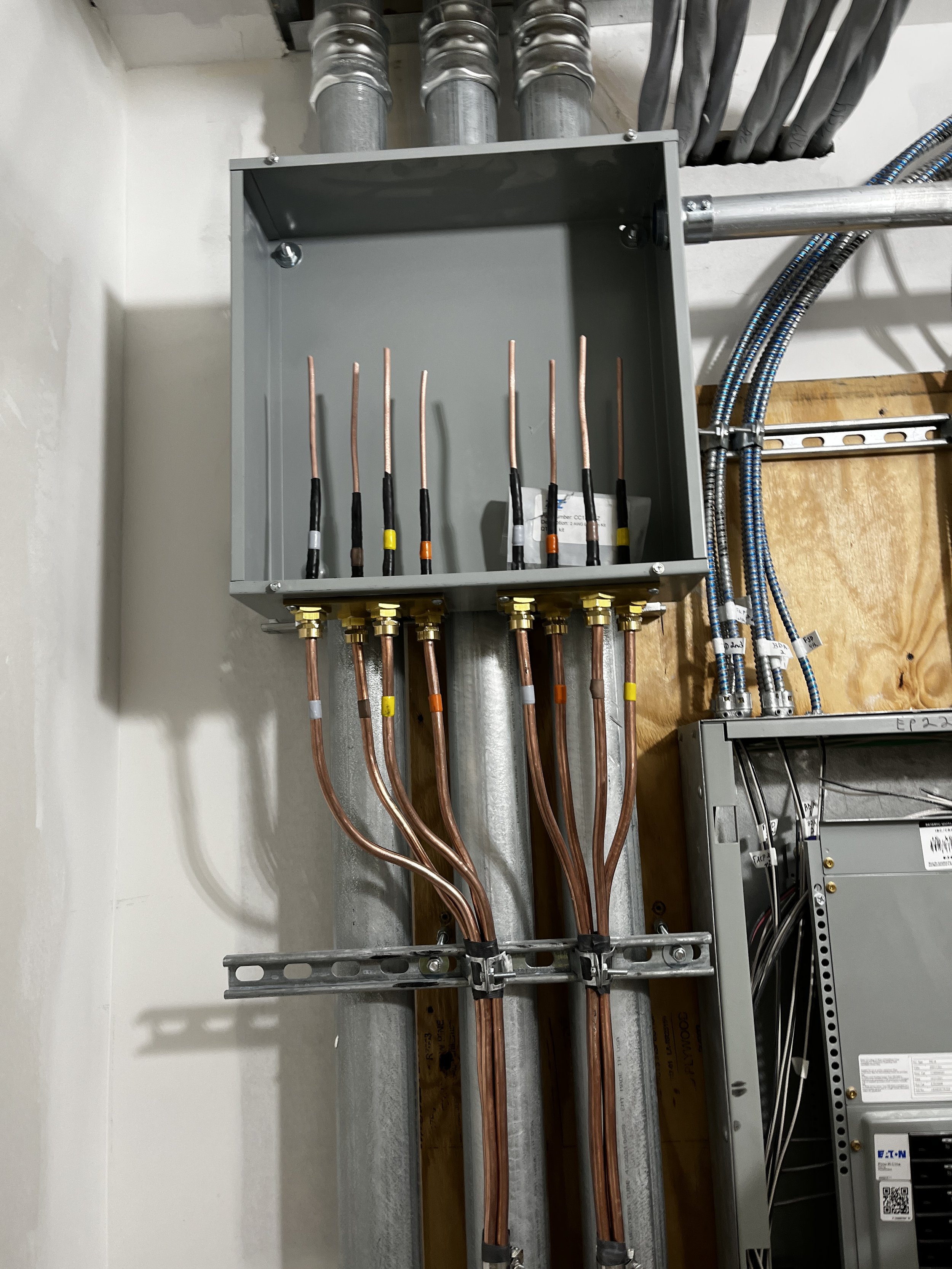 Electrical panel with exposed copper wires and conduits partially installed