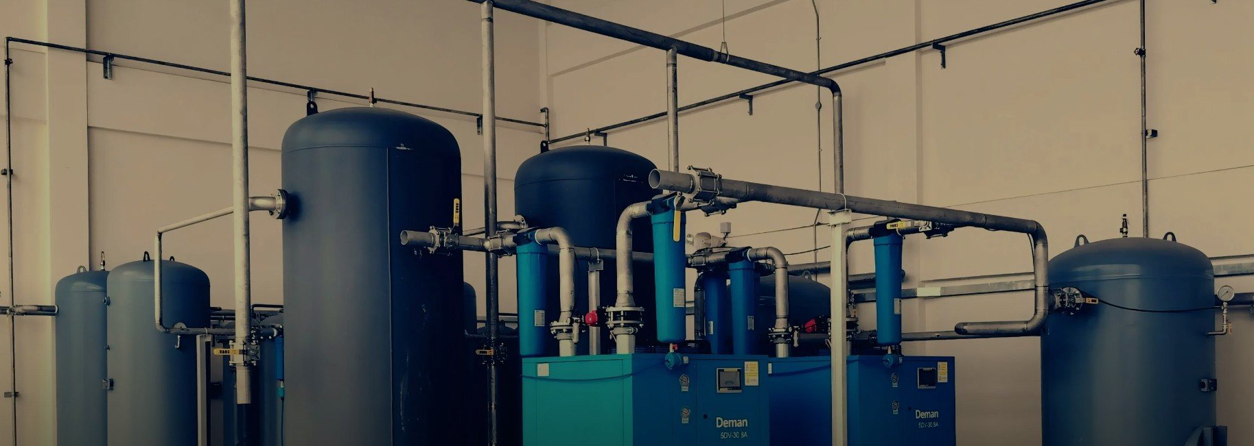 Industrial water treatment system with large blue tanks and interconnected piping in a facility.