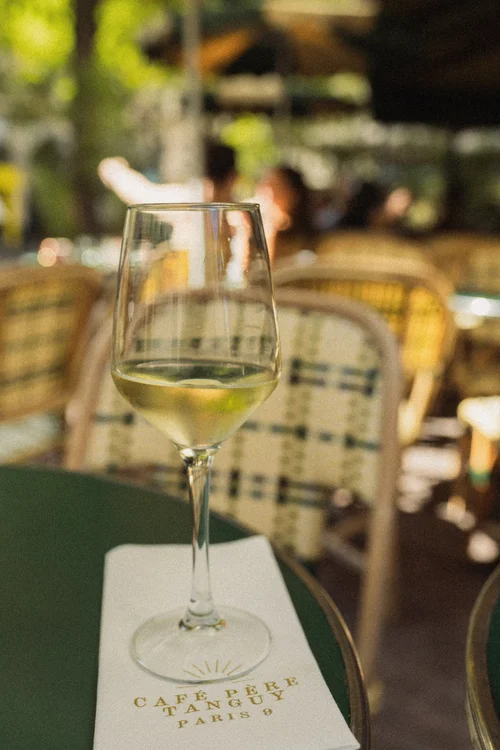 Glass of white wine on a café table in Paris