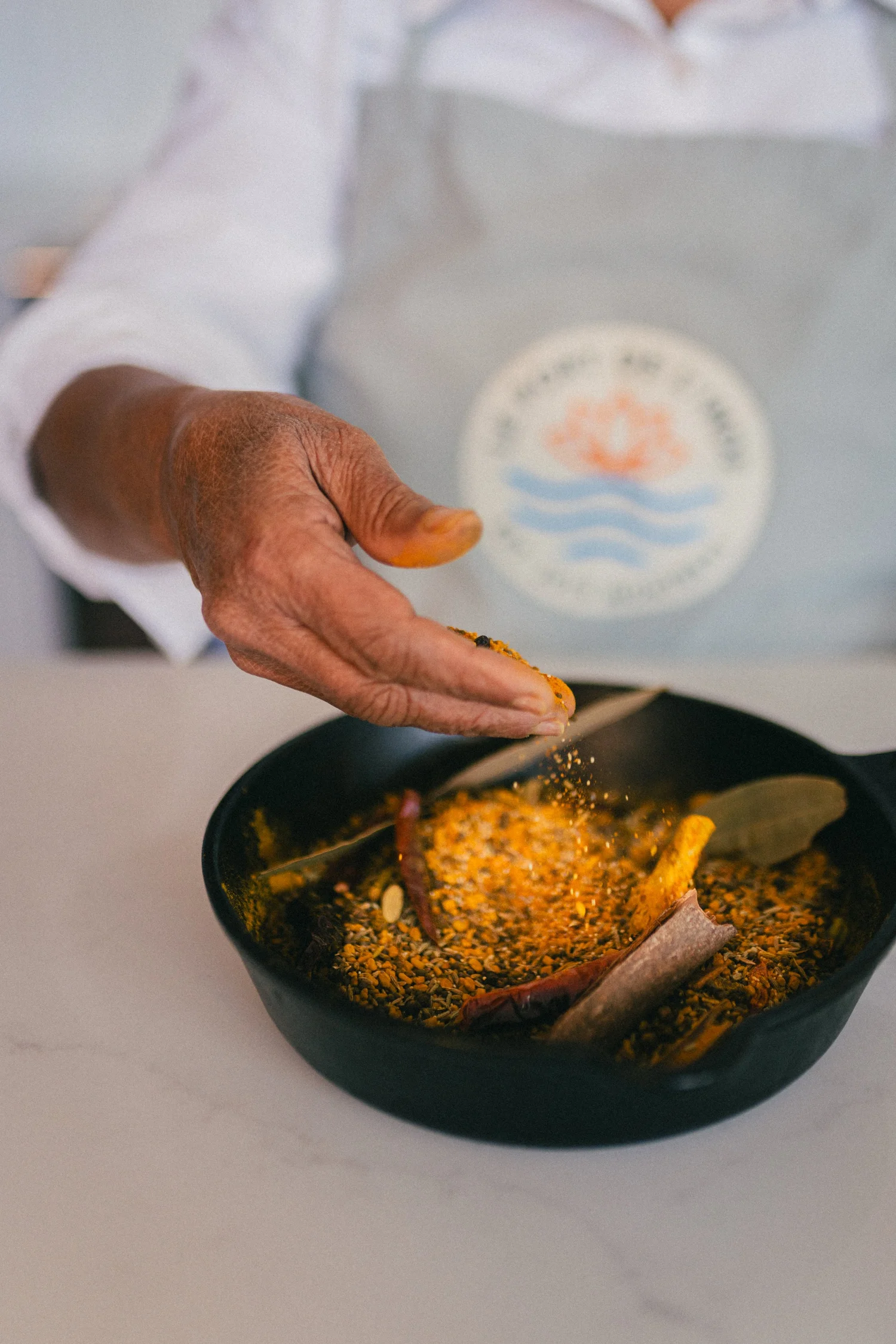 Hand seasoning a skillet of spices