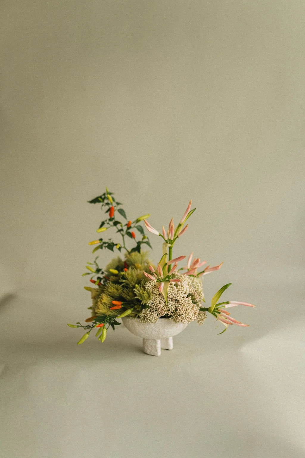 Fall floral arrangement of lilies and greenery in a footed ceramic bowl, photographed for Art et Fleurs, a Montréal florist