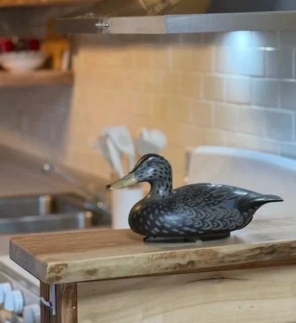 Decorative duck figurine on a wooden kitchen counter.