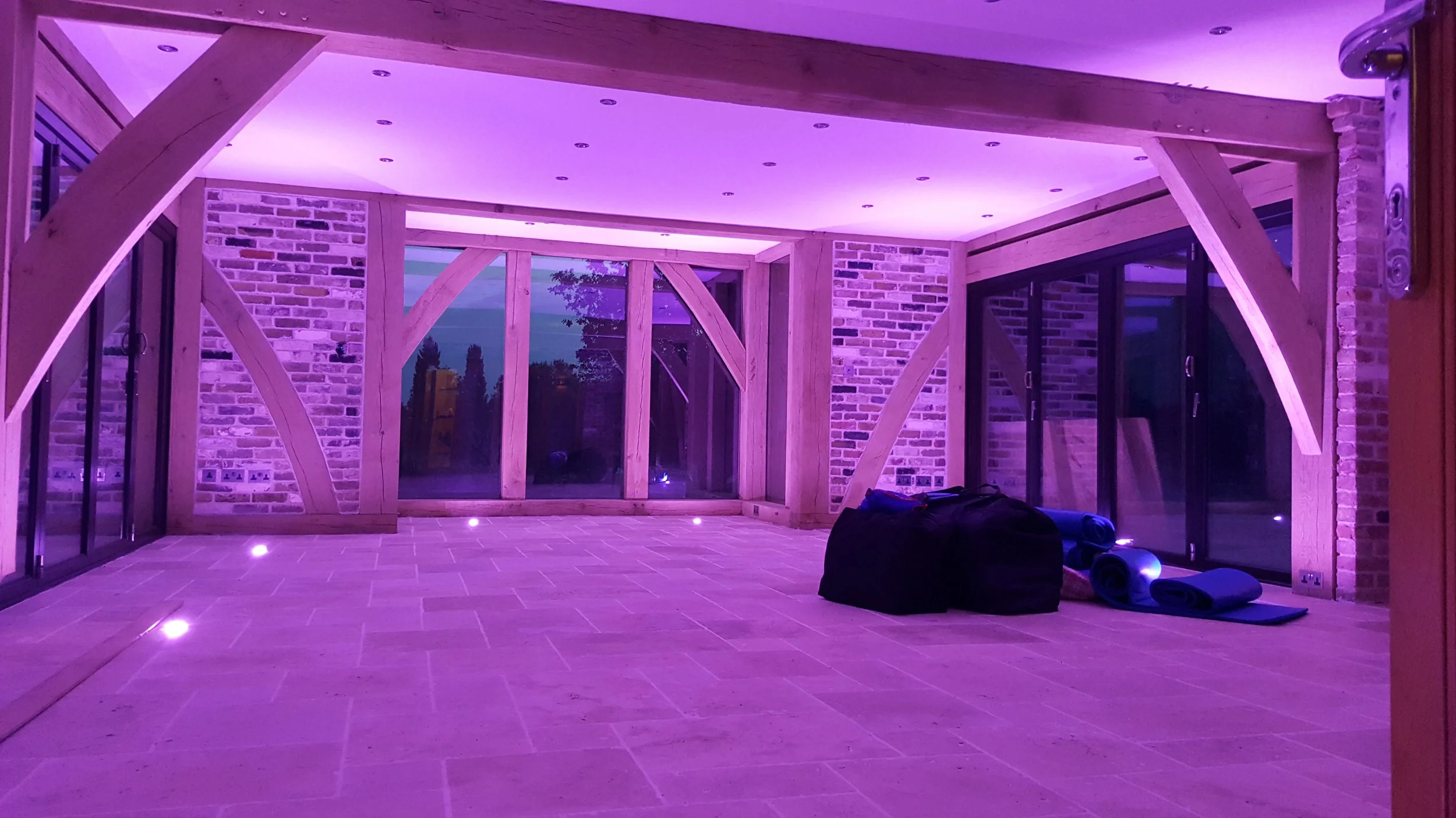 Modern LED lighting design installed in a timber-framed extension with recessed spotlights and ambient floor lighting