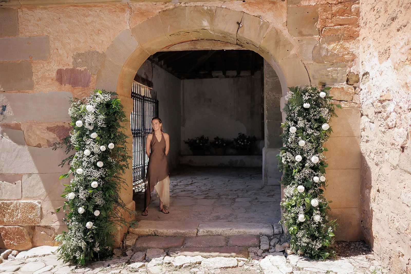 Decoración de la entrada de la iglesia, formado con dos columnas con verdes, crisantemos blancos y paniculata.