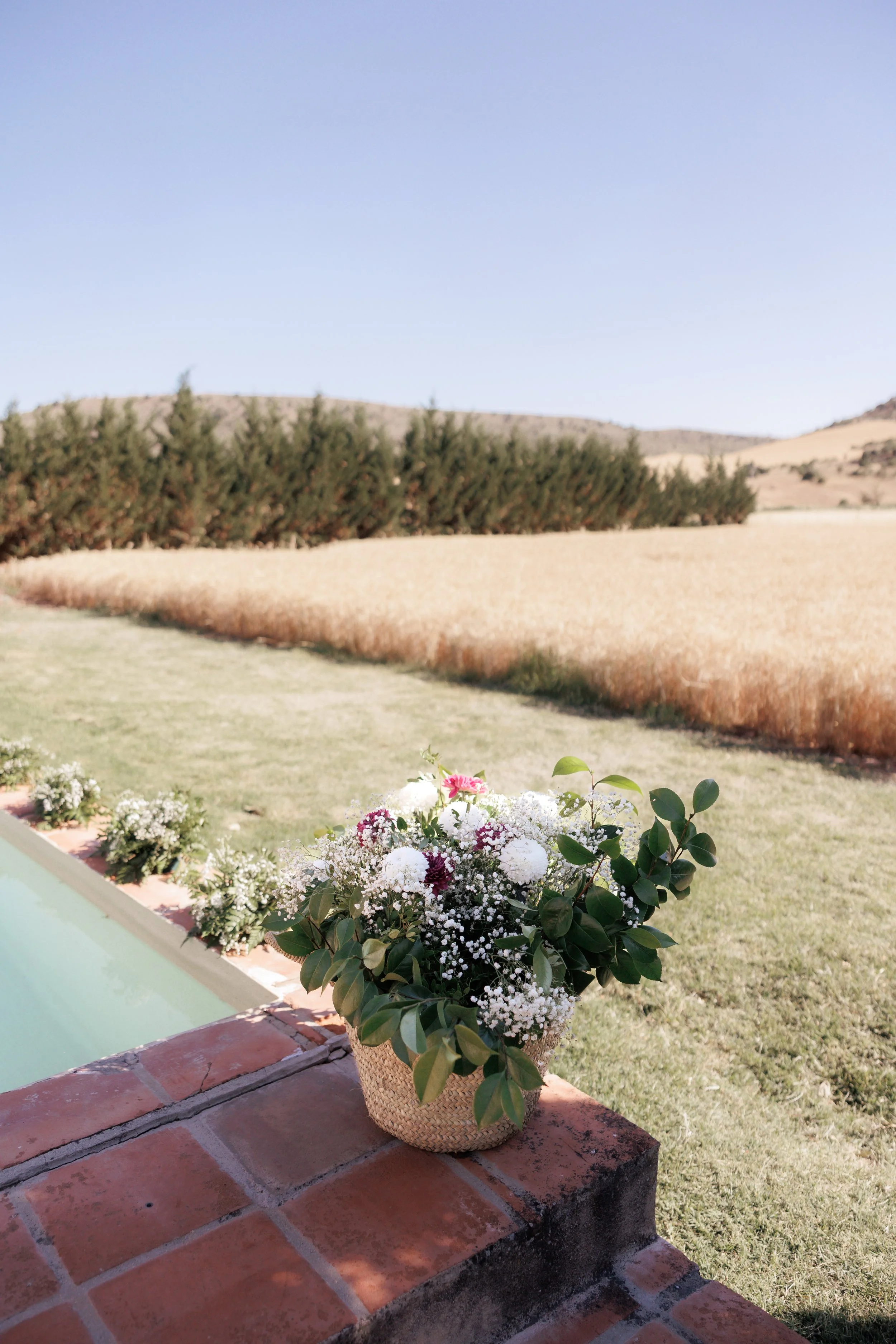 Decoración floral de boda de la finca con cesto de mimbre.