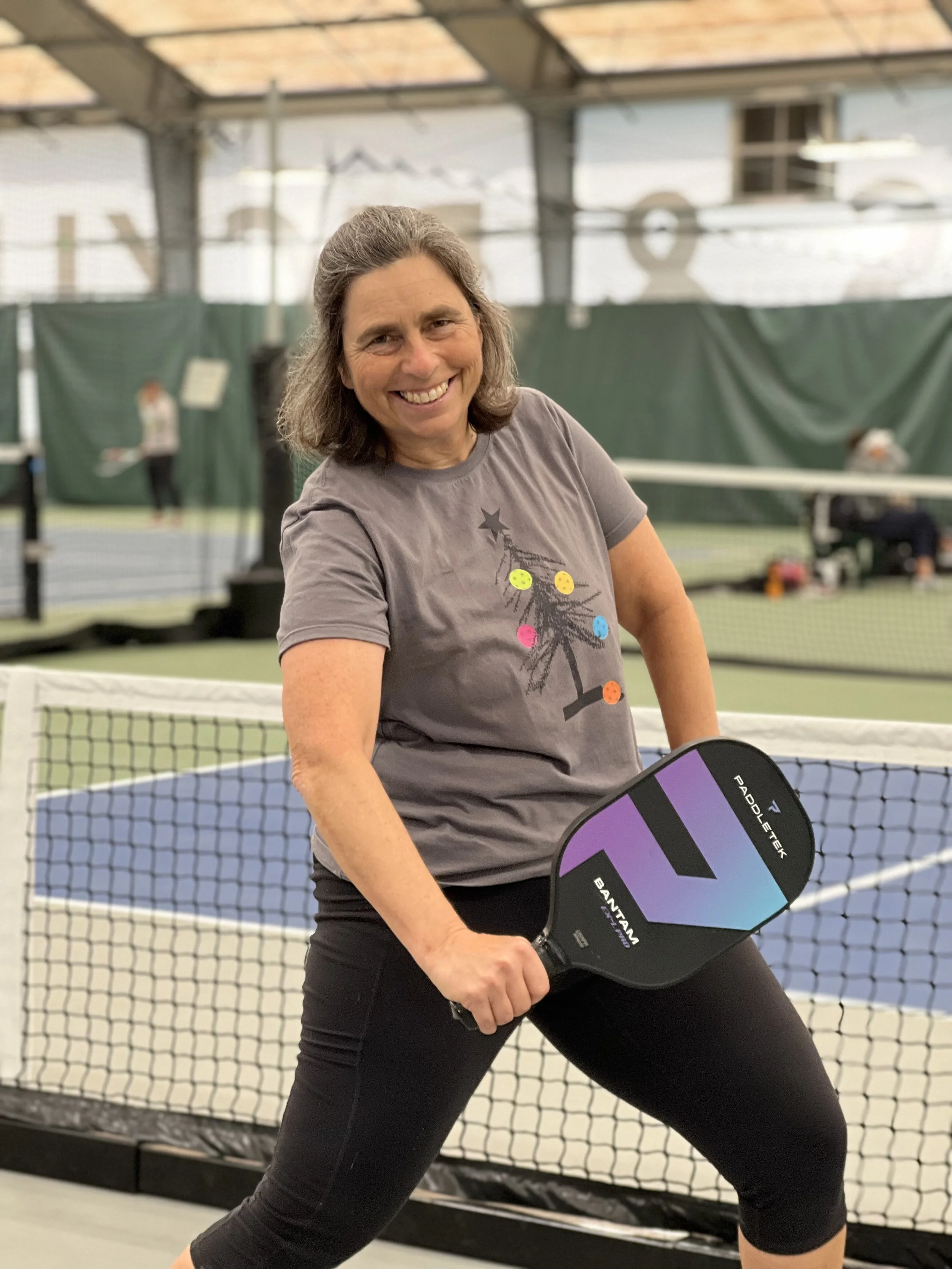 Martha Ehrenfeld in front of a pickleball court.