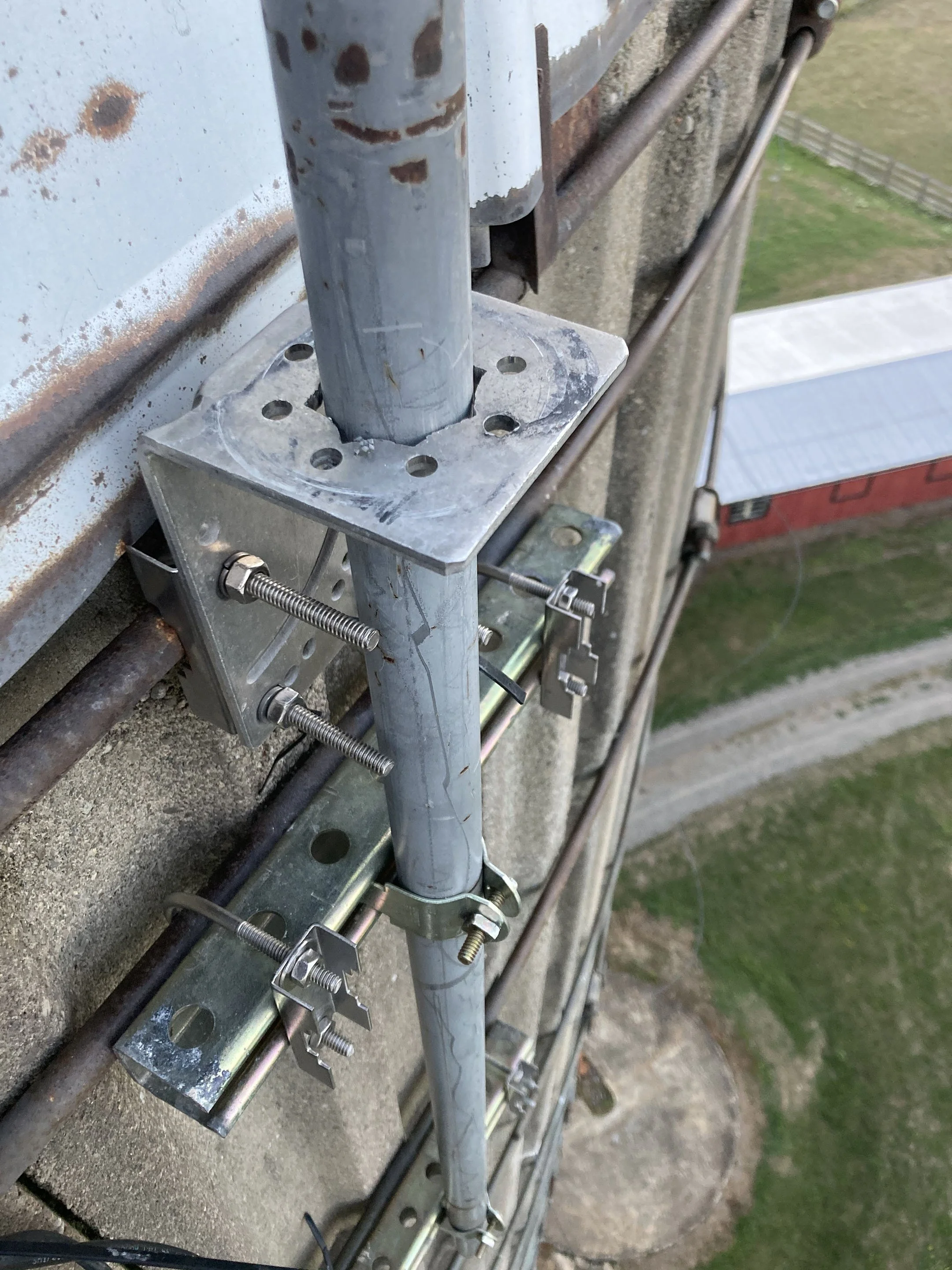 Metal scaffolding secured to a concrete wall with clamps and brackets.