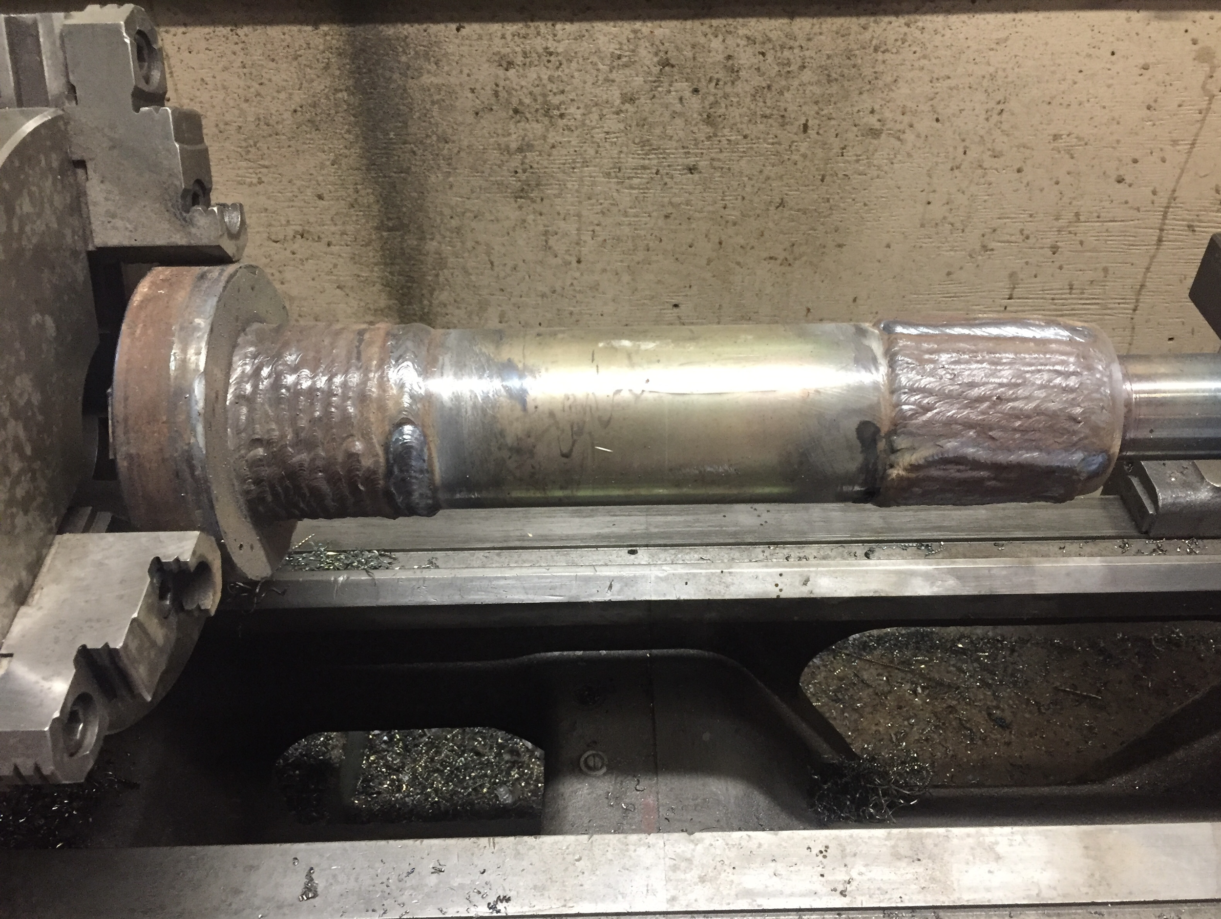 Heavy equipment repair machining, pin weld build-up in progress, ready for machining.