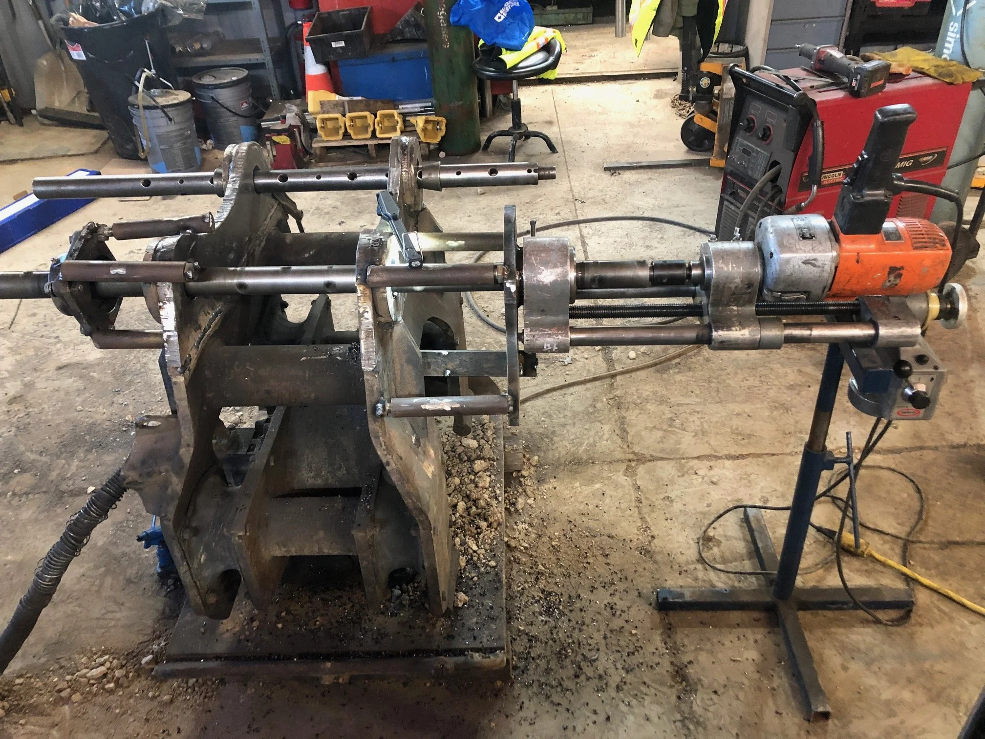 Heavy equipment repair, line boring on an excavator packer attachment in progress.