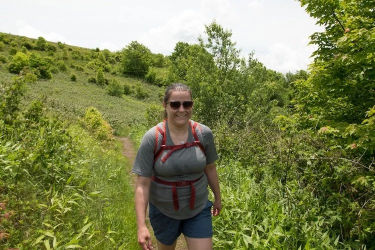 Dr. Katie hiking outdoors on a backpacking trip to soothe her mental health.