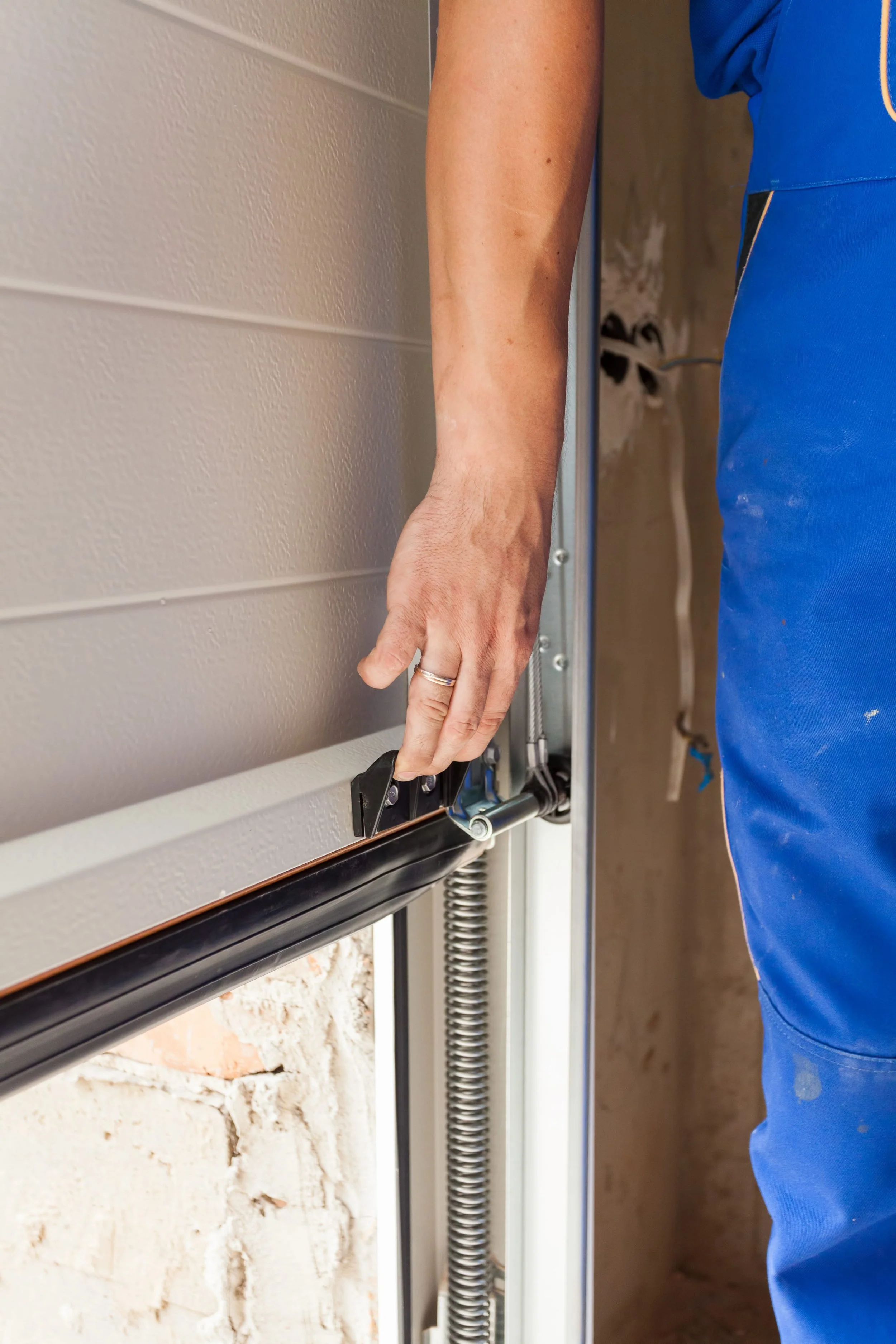 Garage door technician performing professional garage door repair and spring maintenance for Alpine Overhead Doors in San Diego County.