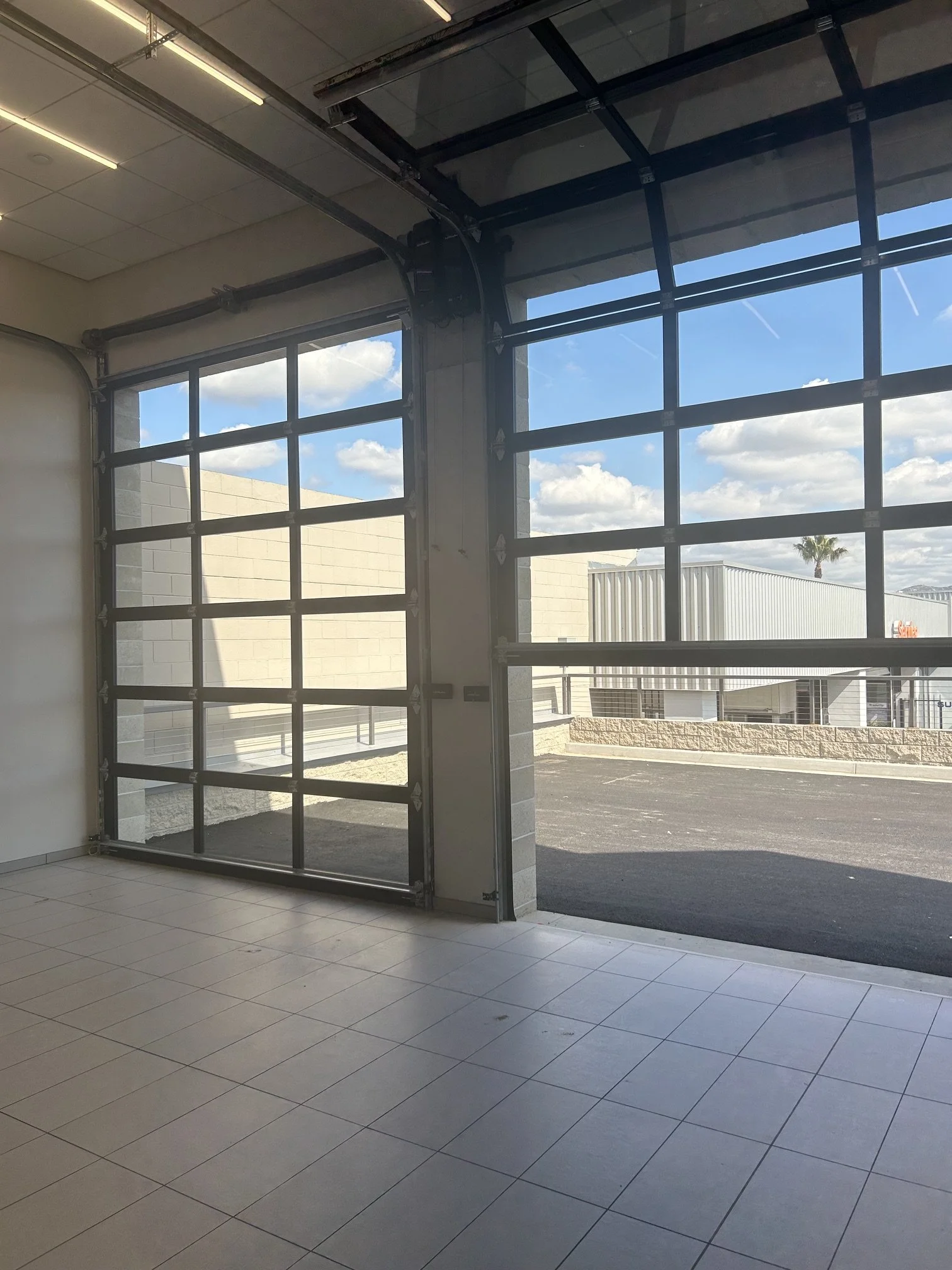 Commercial glass overhead garage doors installed by Alpine Overhead Doors for businesses and storefronts in San Diego County.