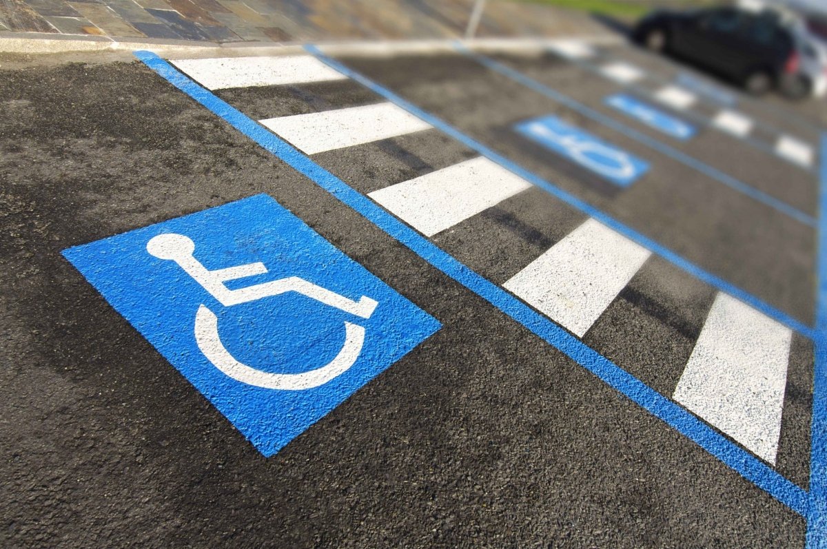 Handicap parking space with blue and white wheelchair symbol painted on asphalt