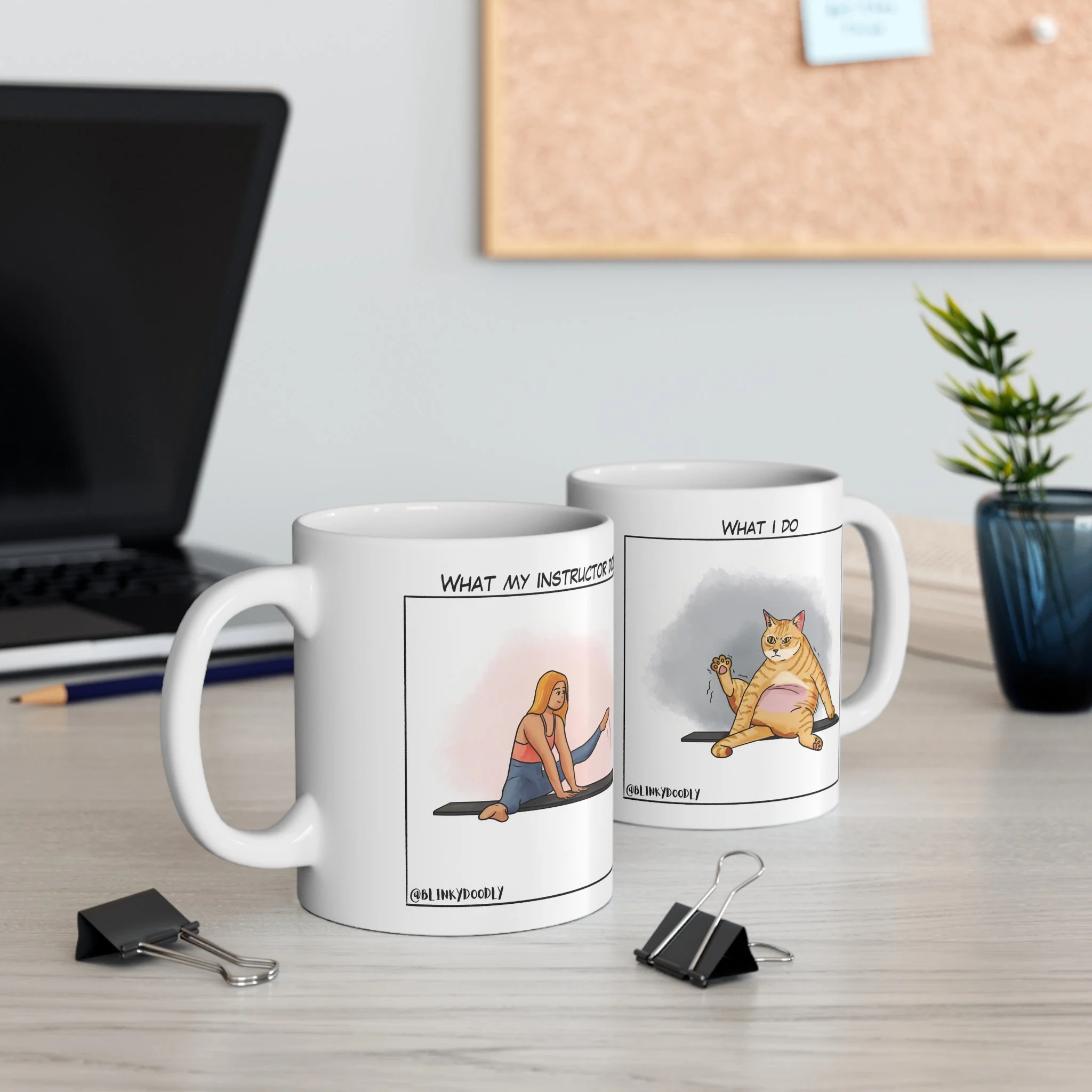 Two white mugs with printed illustrations on a light wooden desk. A gray background with some objects in the back.