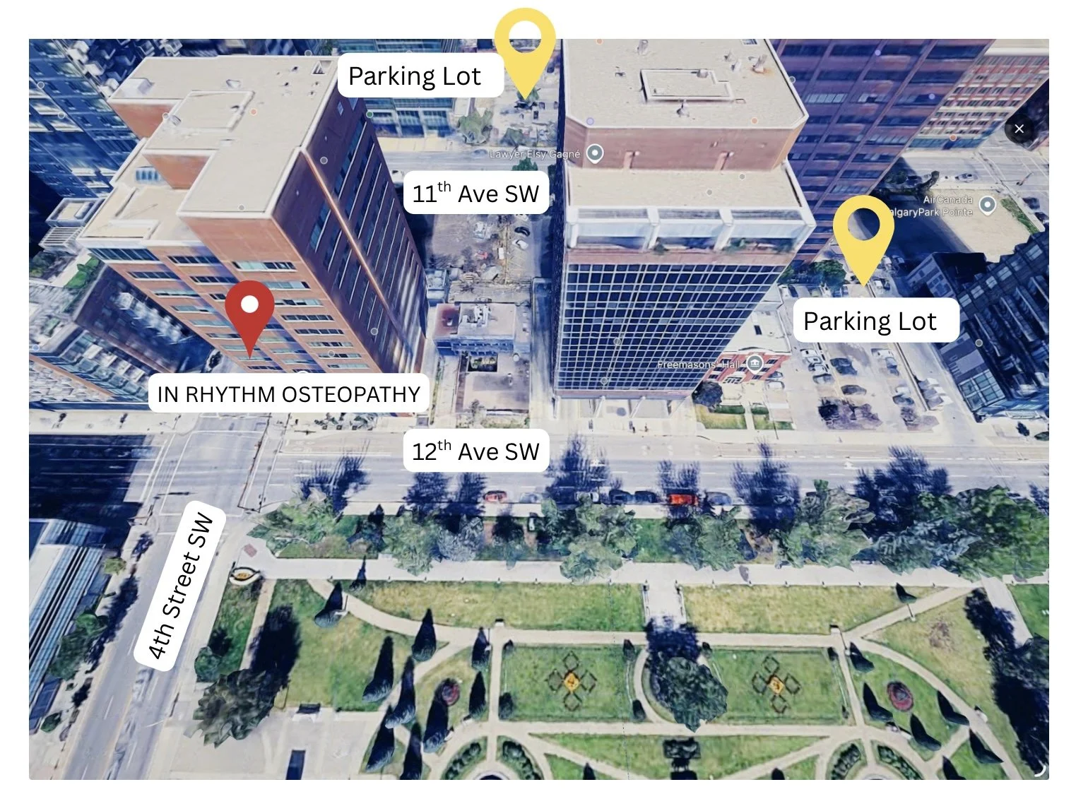 Aerial view of downtown cityscape with buildings, parking lots, streets, and a park. Labels indicate streets, parking lot locations, and a point of interest labeled 'IN RHYTHM OSTEOPATHY'.