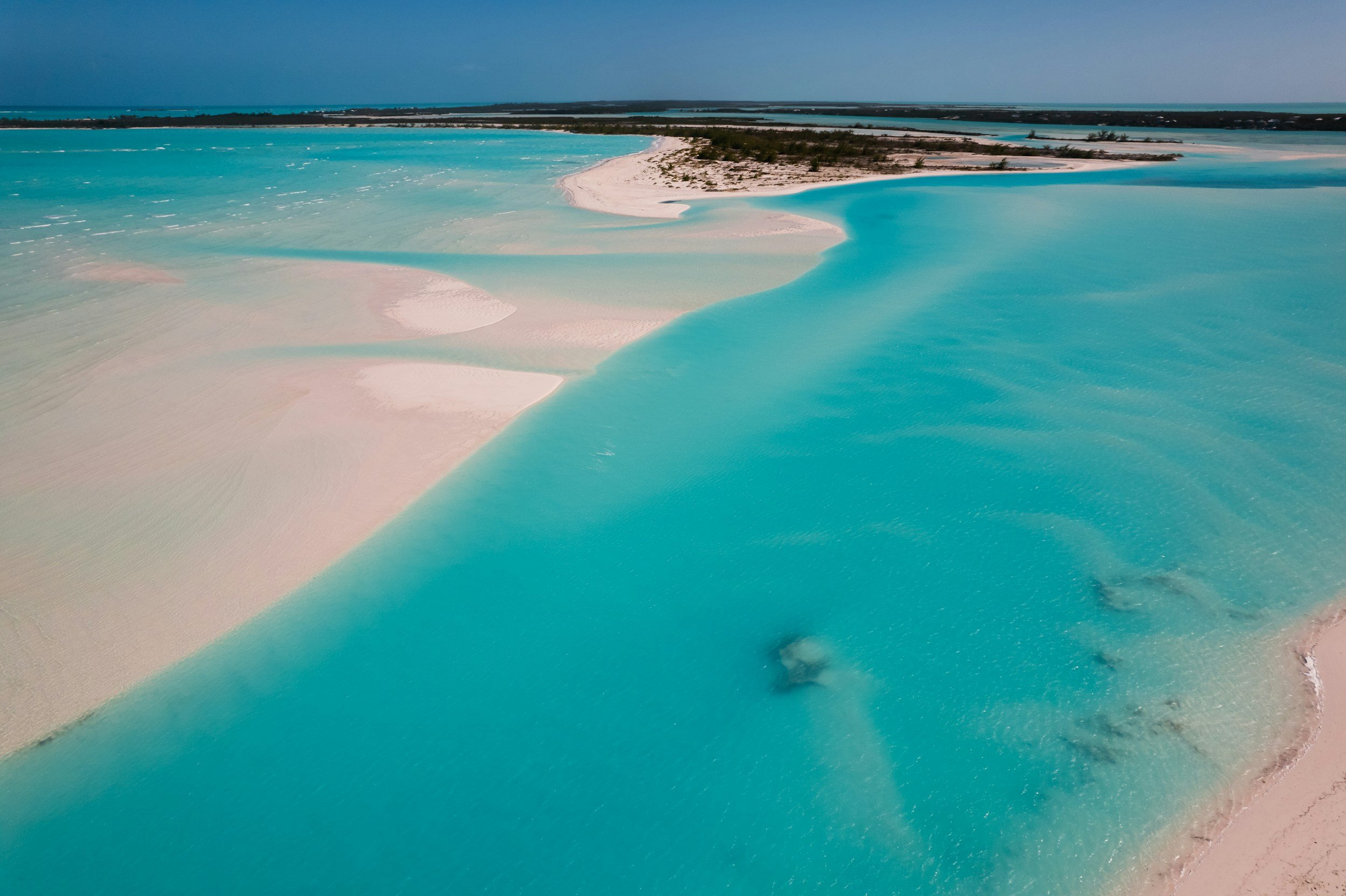 Aerial view of a coastal area with turquoise waters, sandy beaches, and small islands or sandbars.