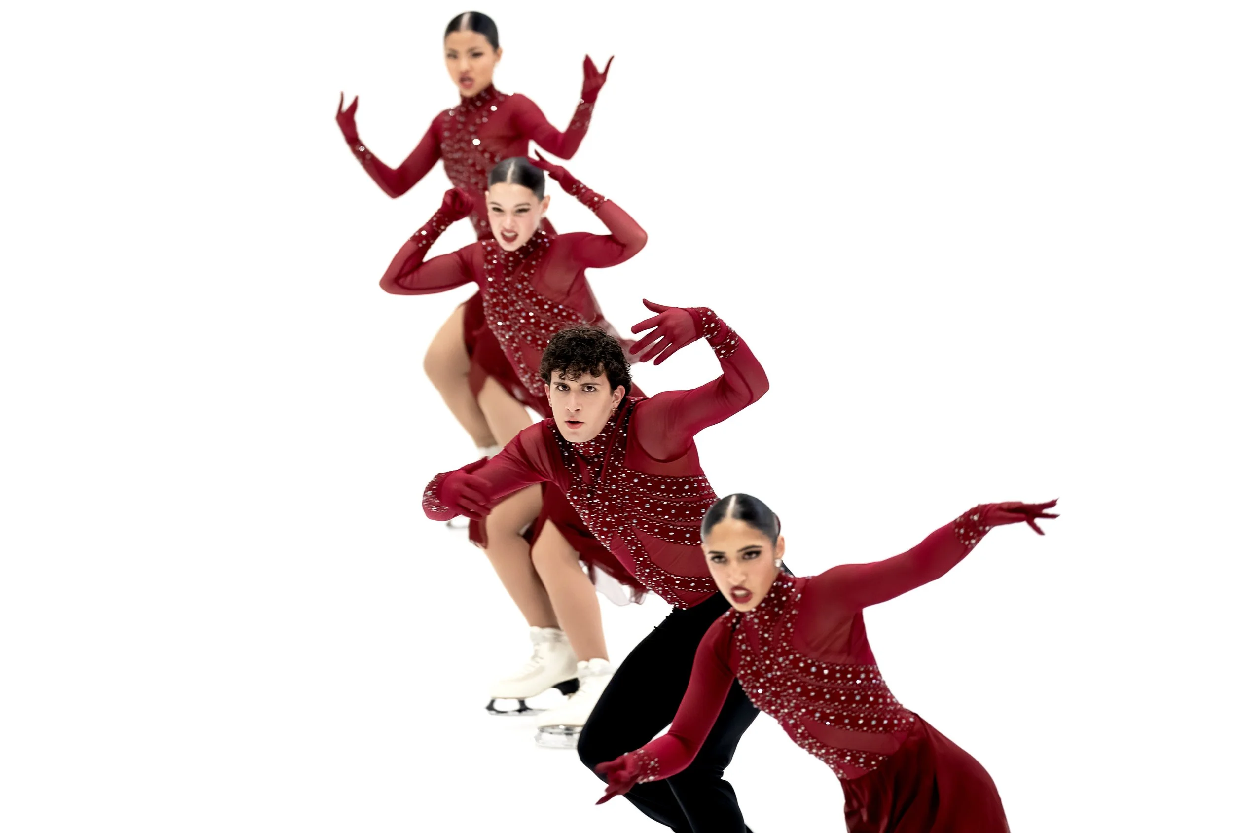 A group of figure skaters in red costumes performing a synchronized routine on ice.