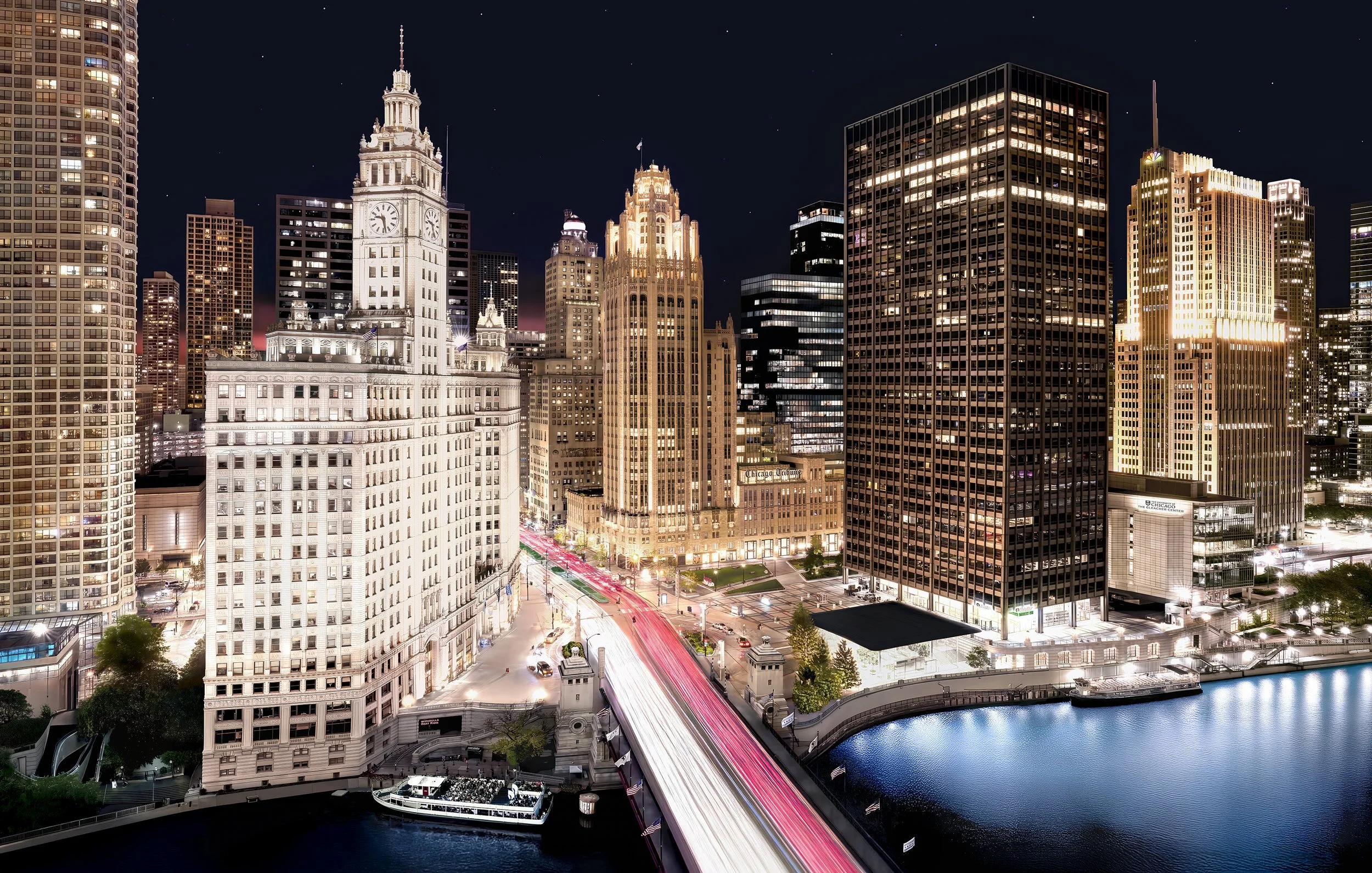 Nighttime cityscape of downtown Chicago with lit buildings, a river, and a bridge with streaks of light from moving vehicles.