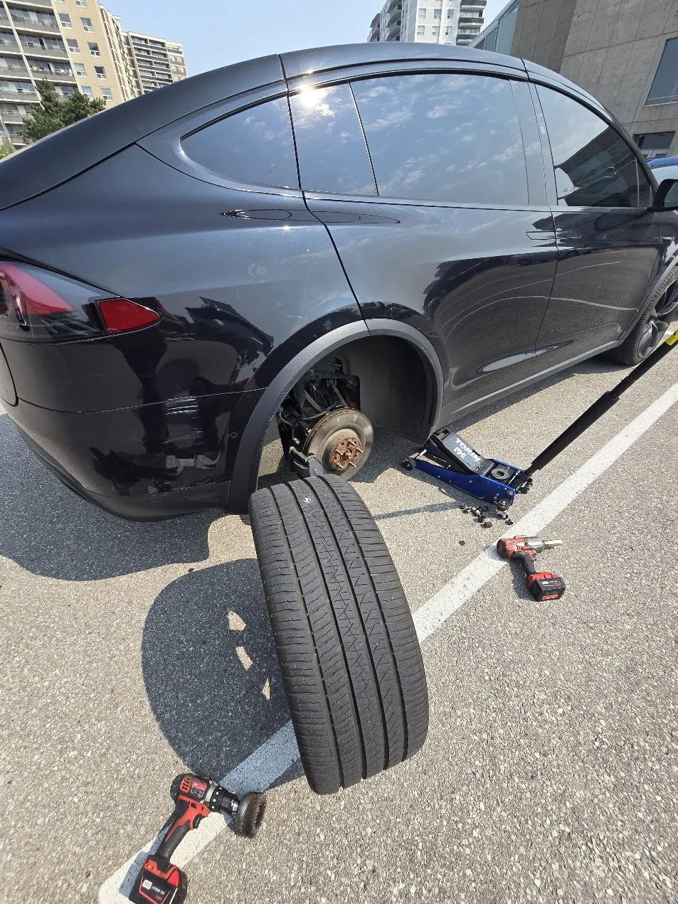 Tesla mobile tire repair - removing the right rear wheel on a Tesla Model X to repair the punctired tire, in North York, Ontario.