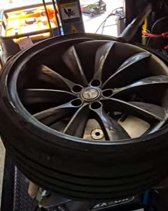 Tesla flat tire repair in process: an acoustic suppresion foam tire being removed from the rim for plug and patch procedure due to a large puncture, but repairable.