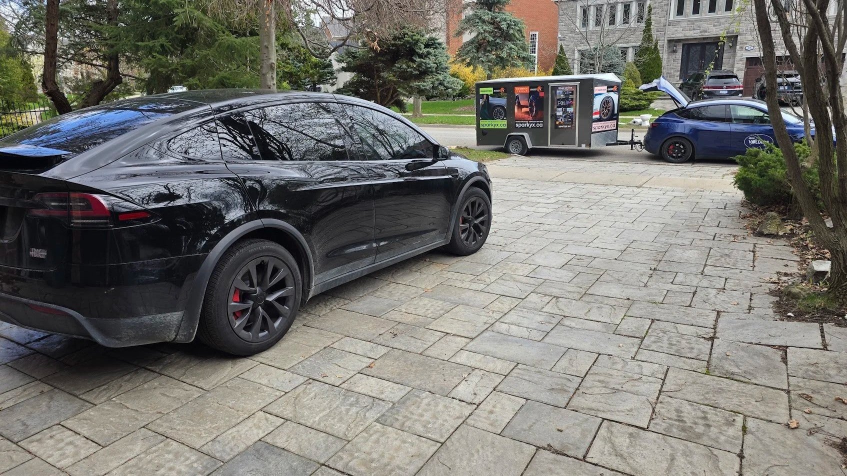 The High Voltage Tire service vehicle is parked near a driveway in Richmond Hill, Ontario, where our technician is performing seasonal tire change for a Tesla Model X Plaid.