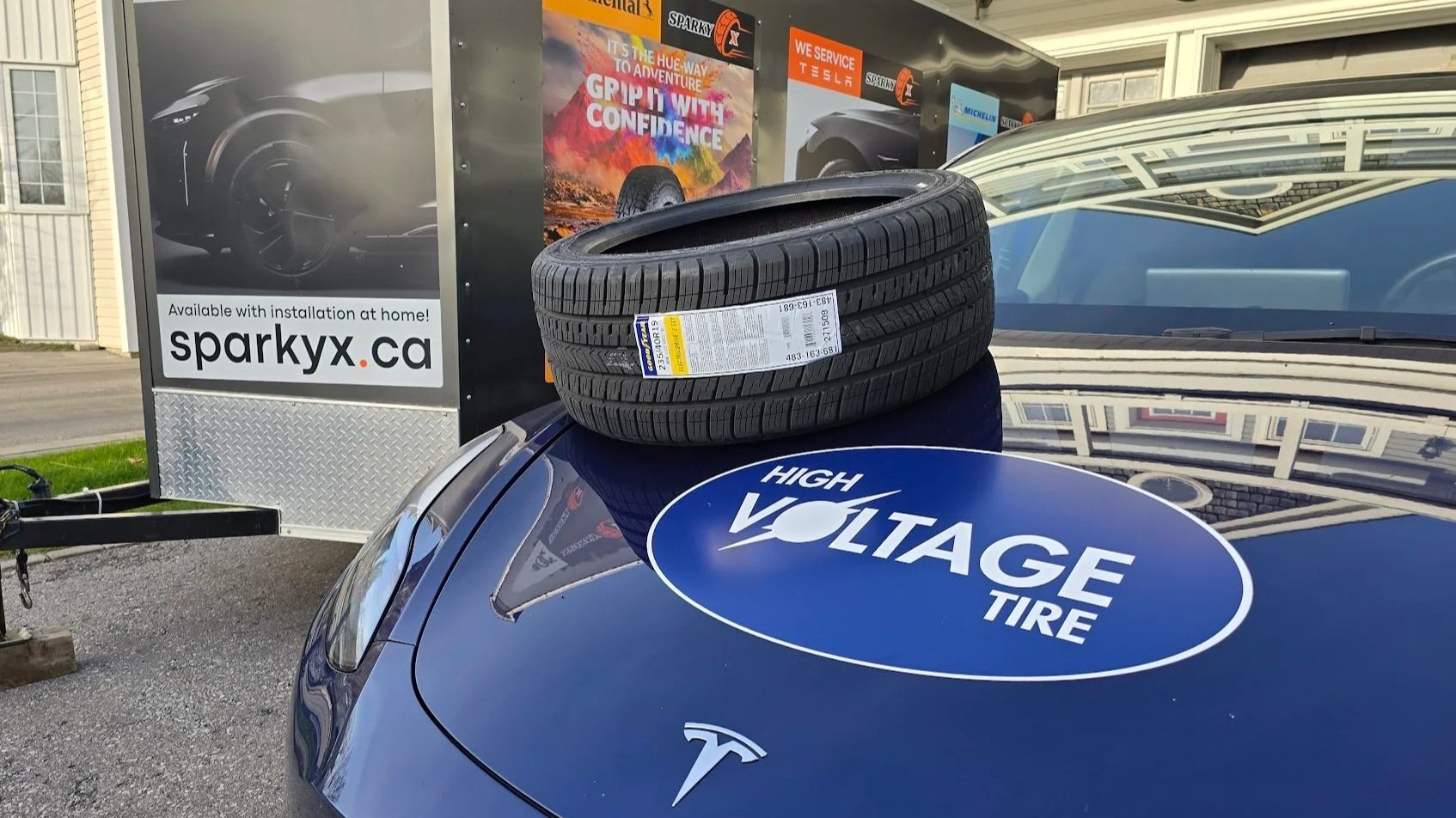 An EV rated tire placed on the hood of a Tesla Model Y service vehicle parked near our service trailer.