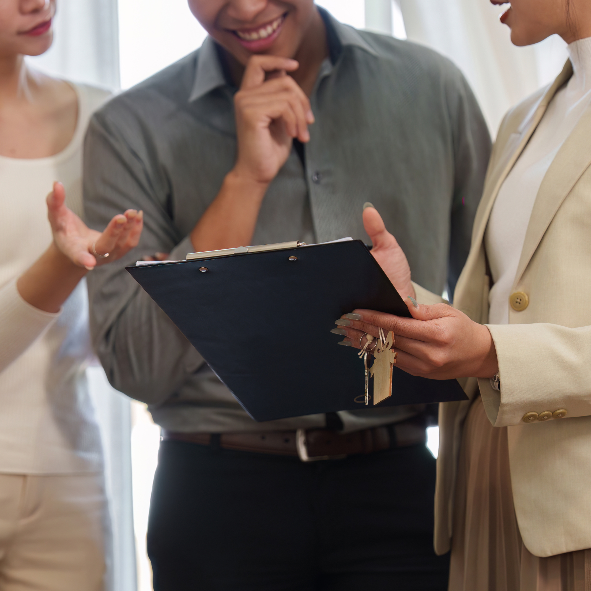 People engaged in a discussion, with one person holding a clipboard and another speaking with hand gestures.