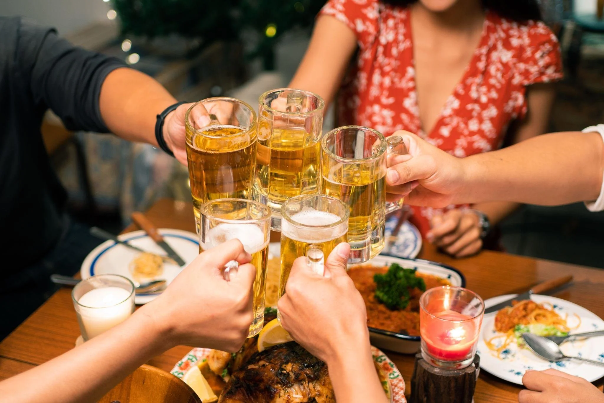People toasting with glasses of beer at a social gathering.