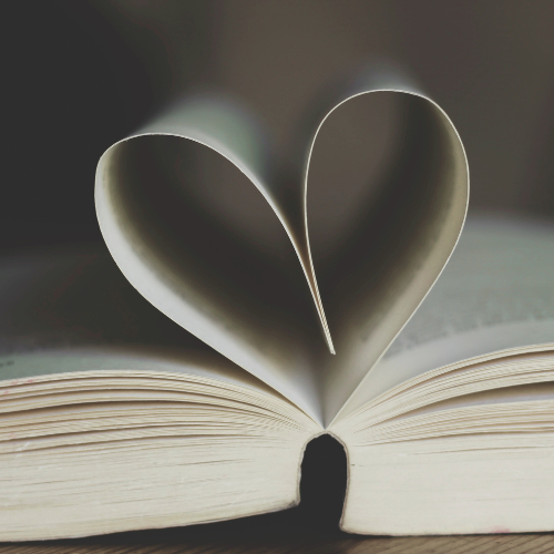 Open book with pages folded to form a heart shape.