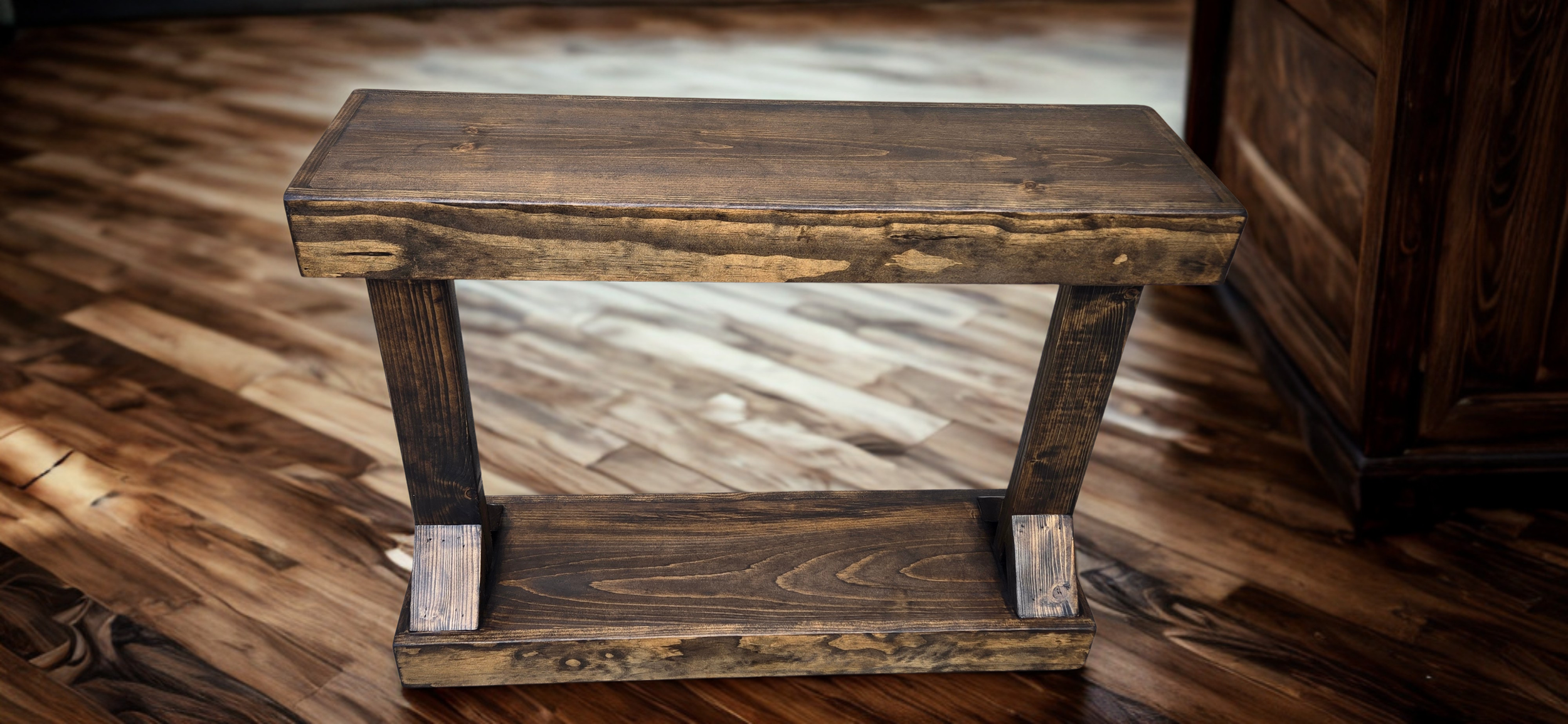 Small wooden side table with a rectangular top and angled legs, placed on a hardwood floor with a wooden cabinet in the background.
