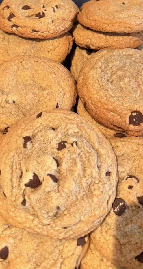 A close-up of chocolate chip cookies stacked together.