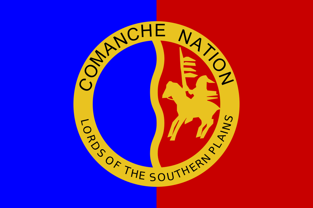 Flag of the Comanche Nation, featuring a blue and red background divided vertically, a gold circular border with the text 'COMANCHE NATION' and 'LORDS OF THE SOUTHERN PLAINS', and a central emblem of a warrior on horseback holding a feathered spear.