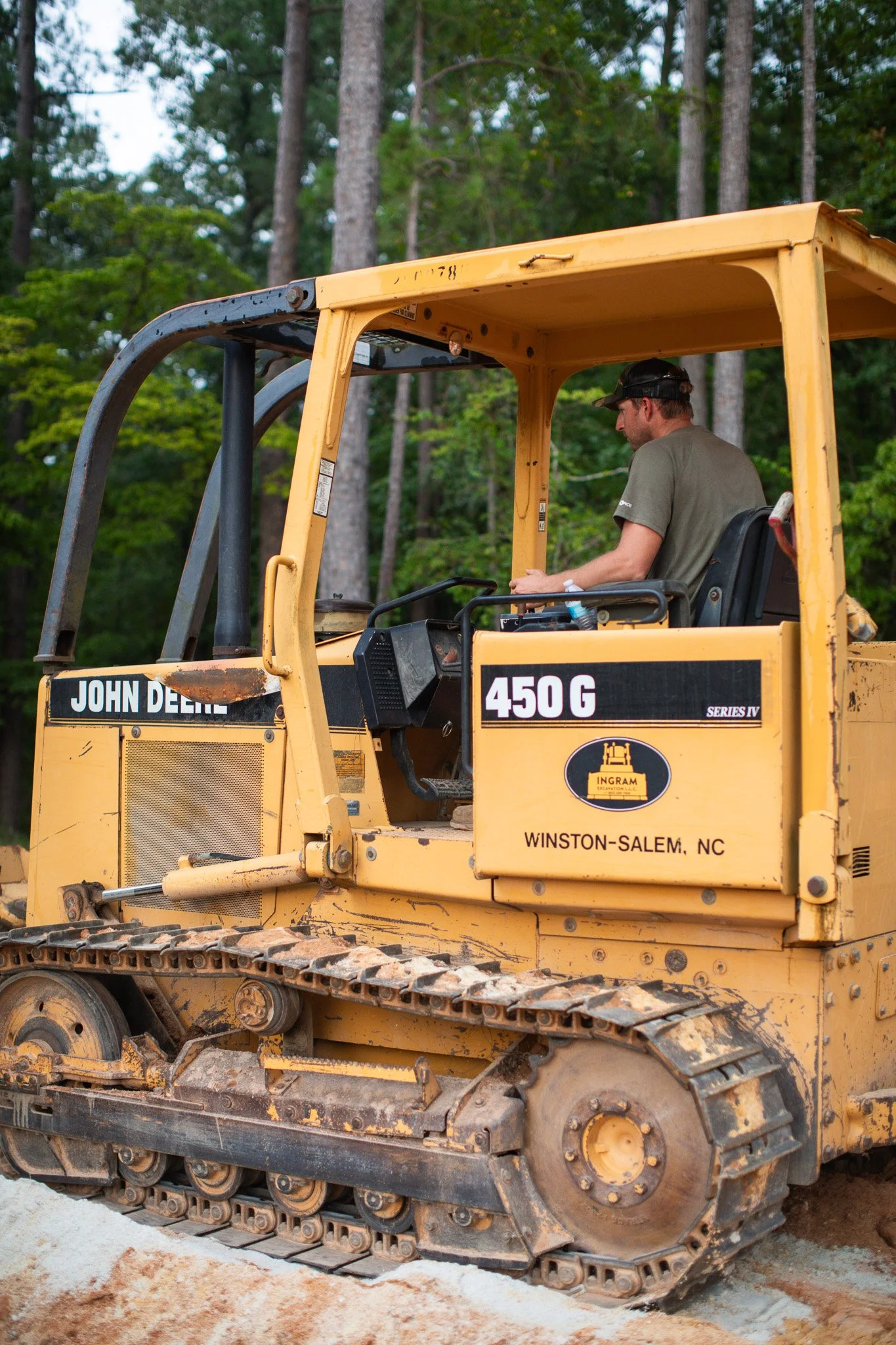A man operating a machinery and hauling rock for driveway installation near Aiken County, South Carolina.