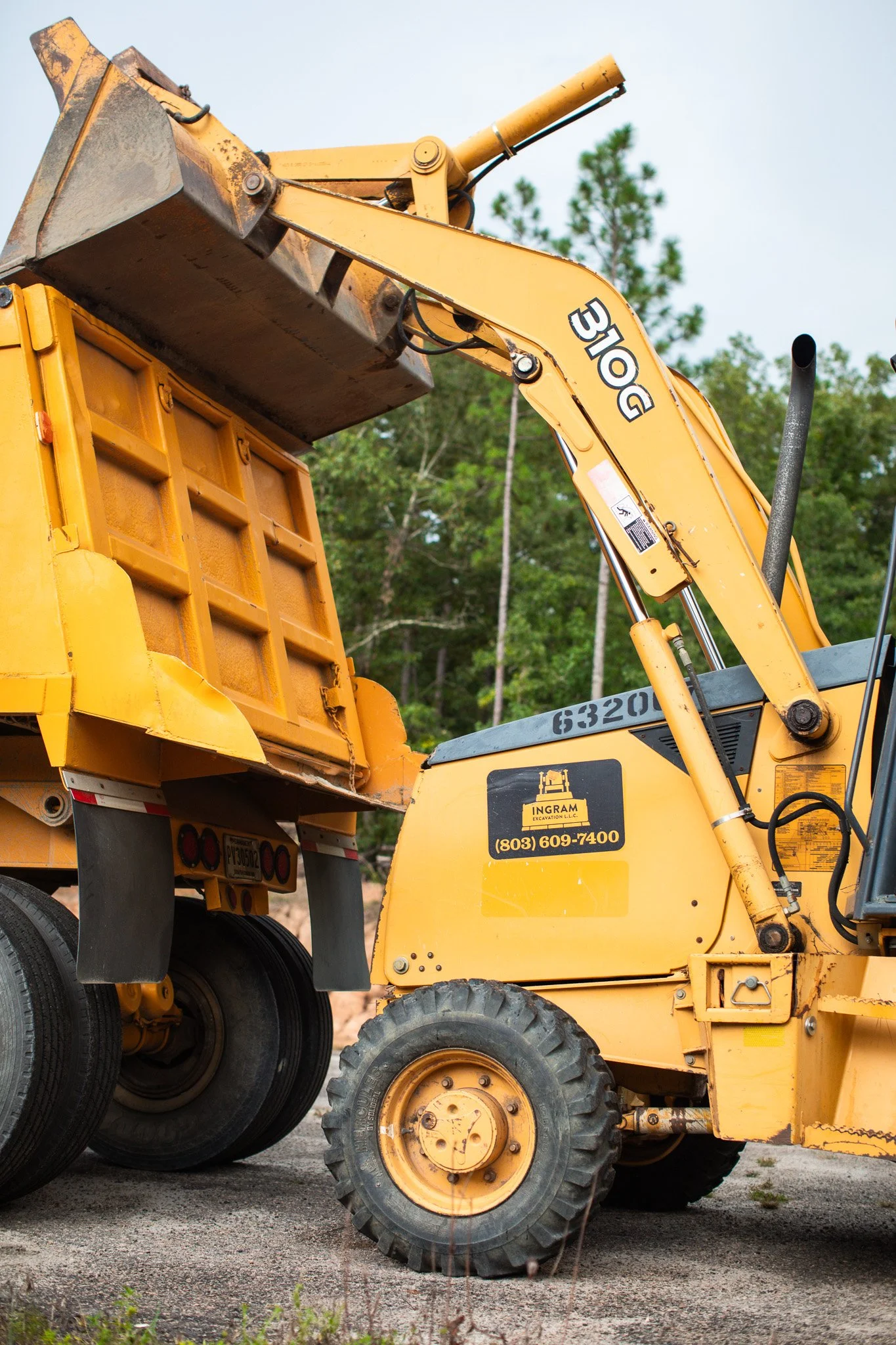 Excavator clearing overgrown land for a new homesite in Aiken County, South Carolina.
