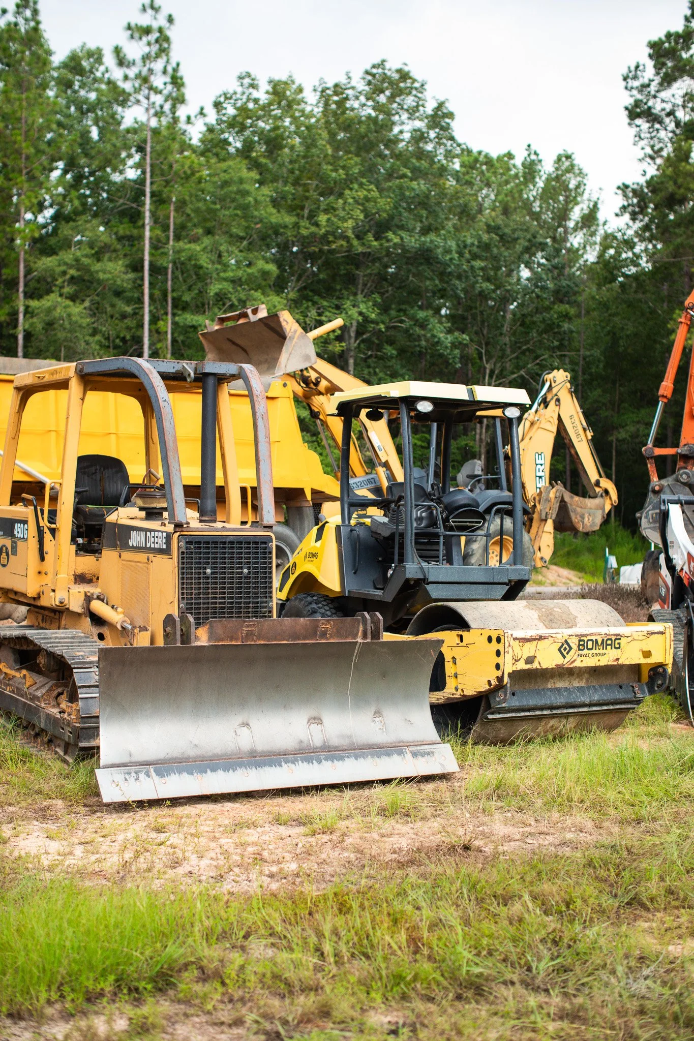 Construction equipment including a bulldozer, compact loader, mini excavator, and other machinery for site preparation near Aiken, SC.