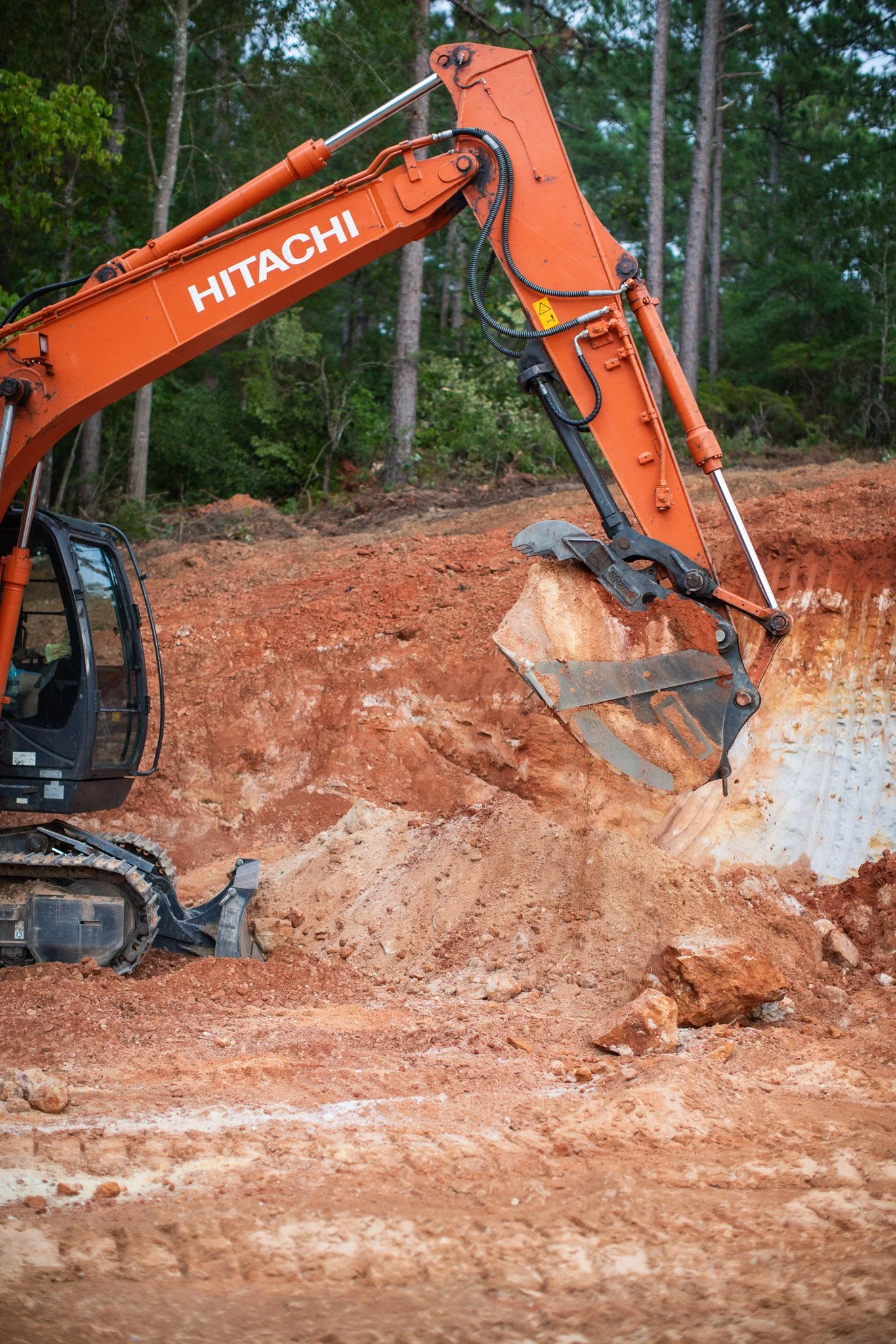 Excavator removing an old structure and dirt during a residential demolition project near Aiken, SC.