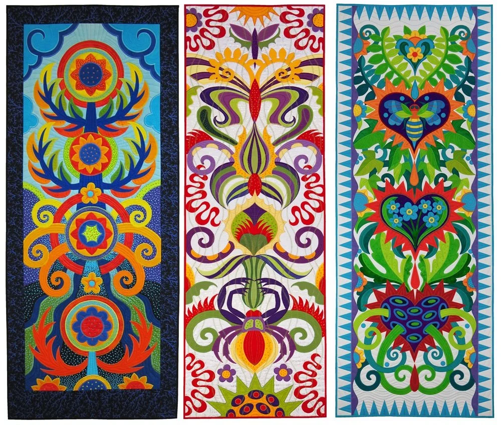 Three colorful, intricate textile or fabric art pieces with symmetrical floral, insect, and abstract patterns.