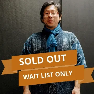 Person standing against a dark wall with a sign that reads "Sold Out" and "Wait List Only"