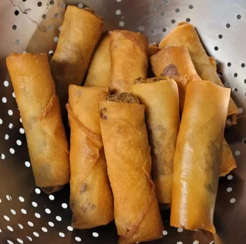 A basket of freshly fried spring rolls.