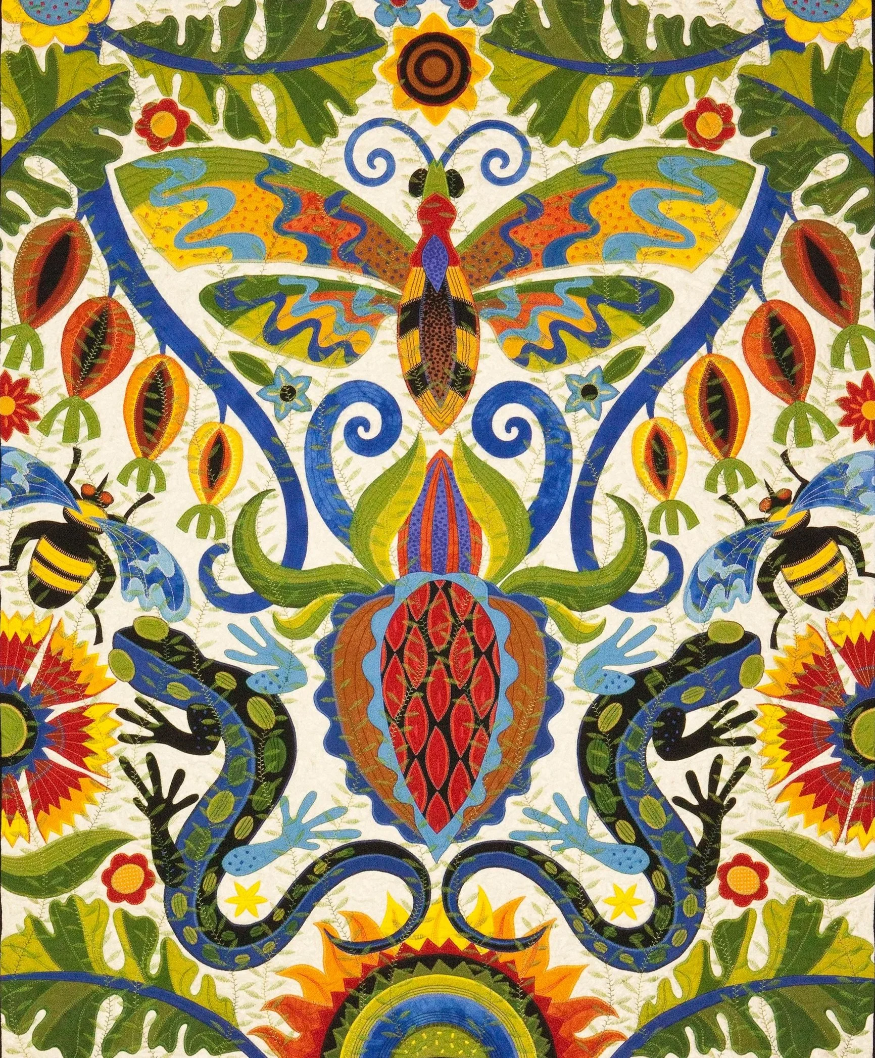 Colorful quilt with a symmetrical pattern featuring a large butterfly at the center, surrounded by floral and geometric designs in vibrant shades of green, yellow, orange, blue, black, and red.