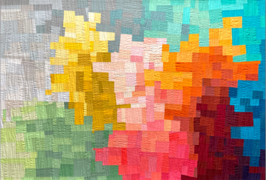 A pixelated mosaic made of colorful fabric patches arranged in a pattern.