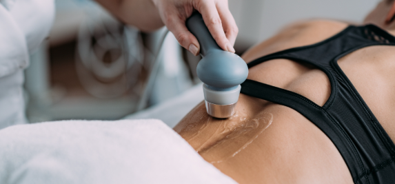 A medical professional uses an ultrasound device on a patient's abdomen.