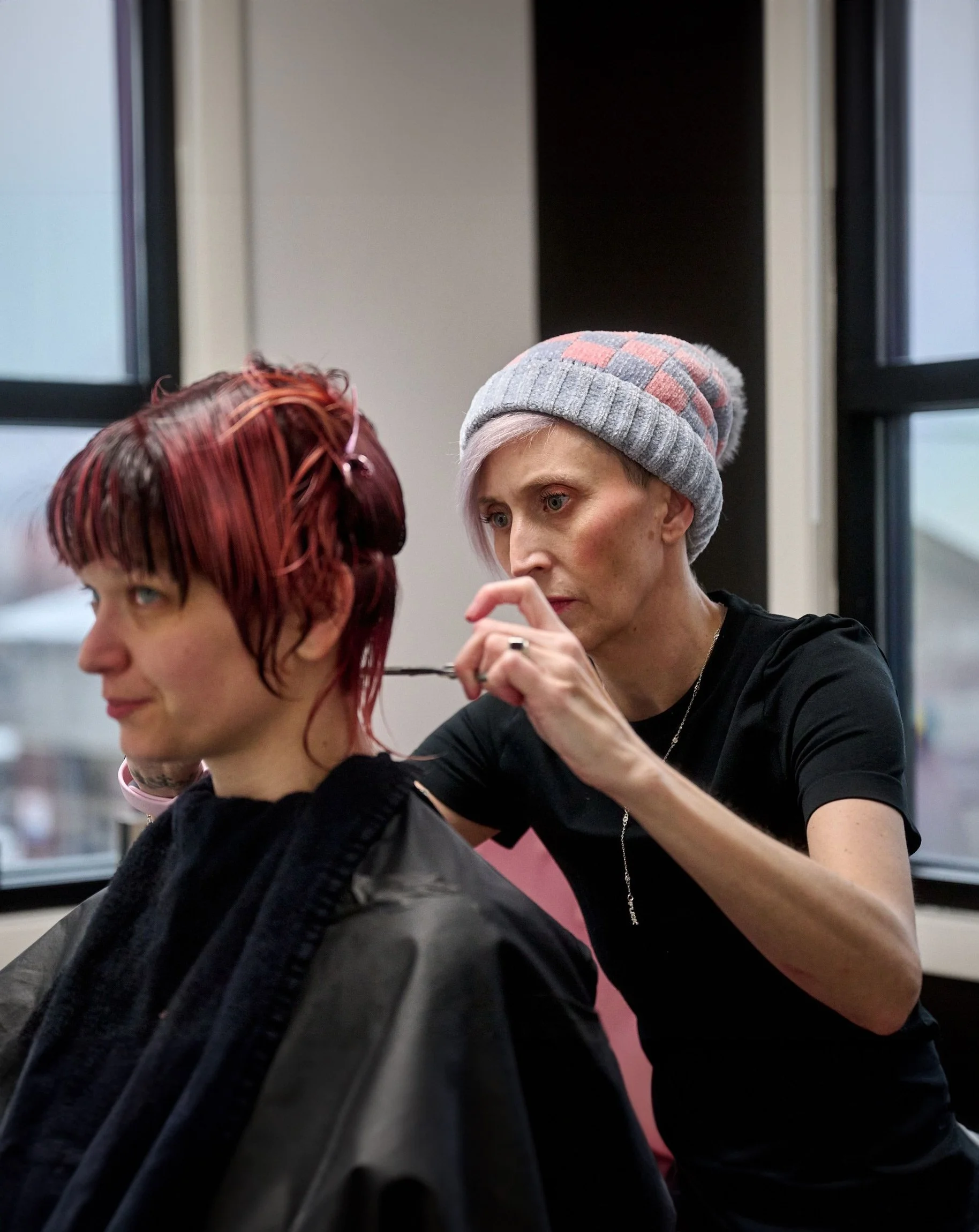 Kelsey cutting hair of seated client